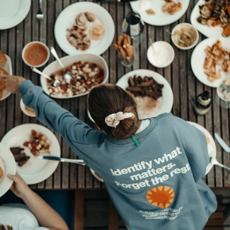 Vogelperspektive auf Gruppe beim Essen im Freien.