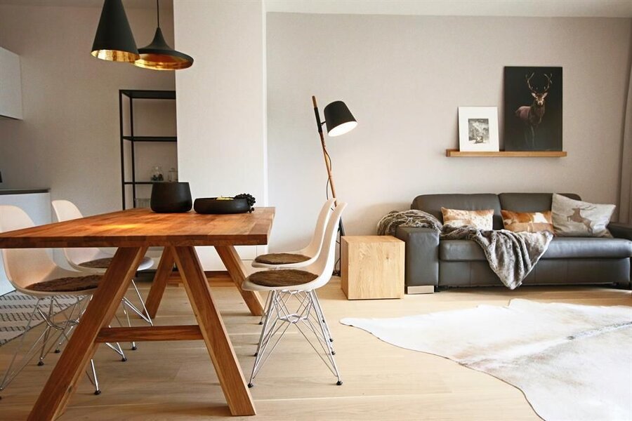 Heller offener Wohn- und Essbereich mit Holztisch und Sofa