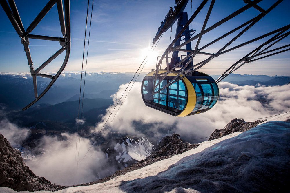 Seilbahn-Gondel fährt über Schnee und Wolken im Gebirge