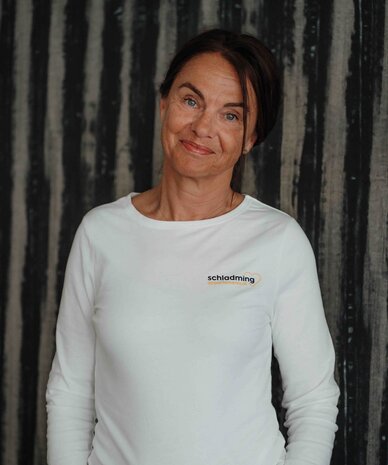 Frau in weißem Langarmshirt mit Schladming-Logo