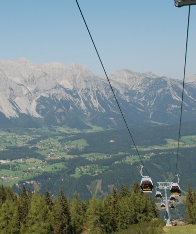 Gondelbahn mit Reiteralm-Schild über Alpenlandschaft