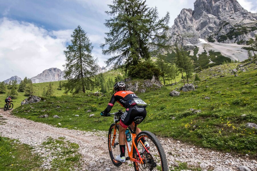 Mountainbiker fährt auf felsigem Weg durch alpines Gelände