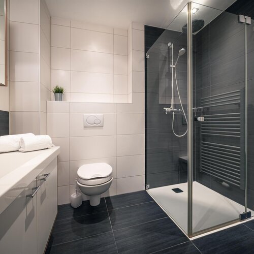 Modernes Badezimmer mit Glasdusche, WC und Waschbecken