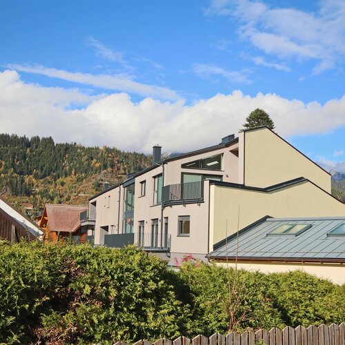 Moderne Wohnhäuser entlang eines Hanggeländes mit Bergen