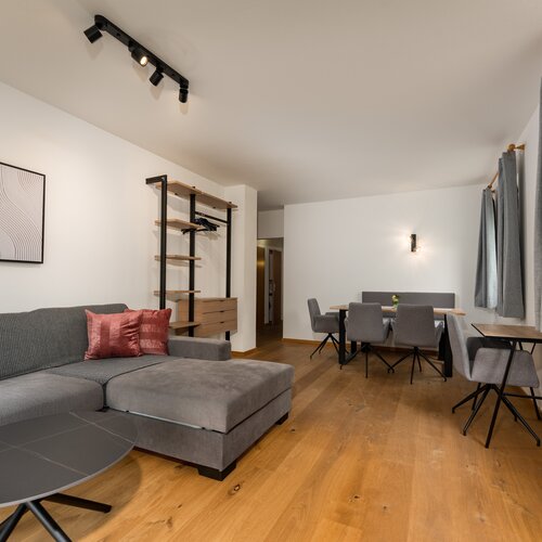 Graue Eckcouch mit pinken Kissen im Wohnzimmer