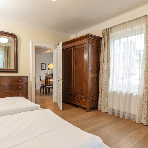 Schlafzimmer mit großem Holzkleiderschrank, Kommode und Spiegel