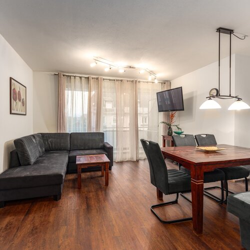 Modernes Wohnzimmer mit grauen Sofas und Esstisch