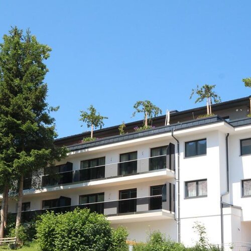 Modernes helles Wohngebäude mit Balkonen und Bäumen