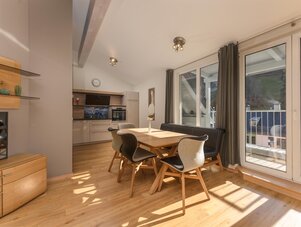 Offener Küchen- und Essbereich mit Holztisch und Stühlen