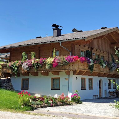 Zweistöckiges Holz-Chalet mit farbig bepflanztem Balkon