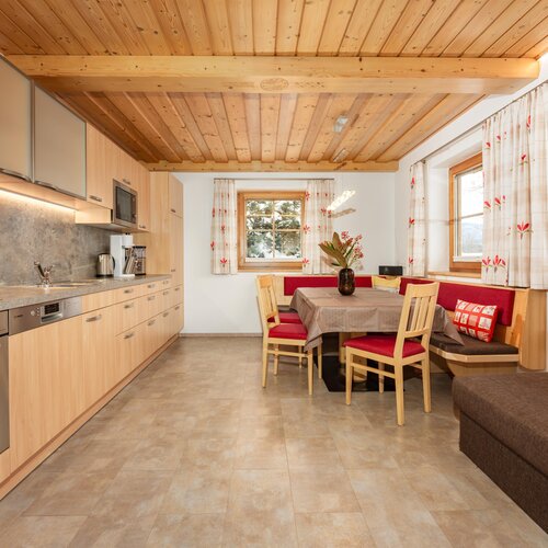 Gemütliche moderne Küche mit Holzbalkendecke und Essecke