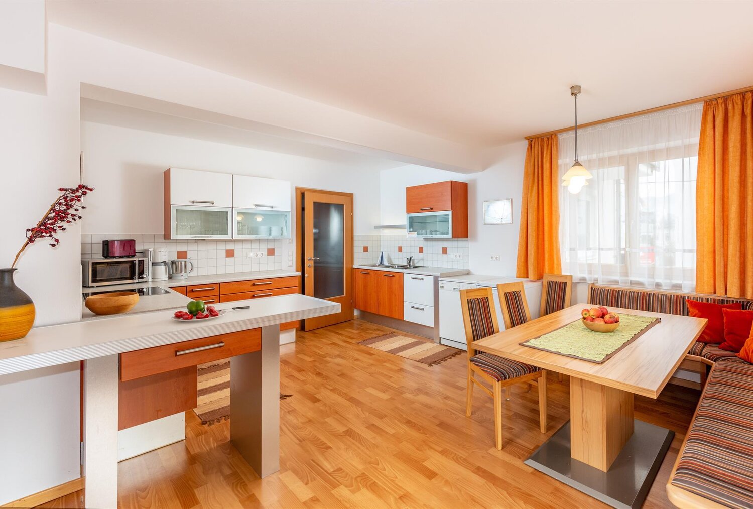 Helle moderne Küche mit Holzmöbeln und Esstisch.