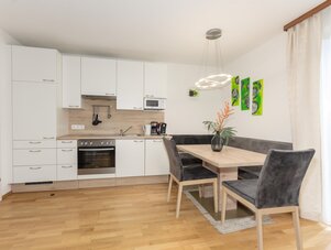 Heller moderner Küchenbereich mit Esstisch und Stühlen