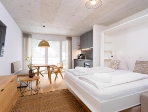 Helles modernes Studio-Apartment mit Bett, Essbereich und Küche