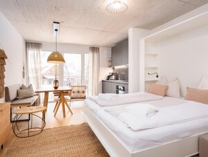 Helles offenes Studio mit Bett, Essbereich und Küche