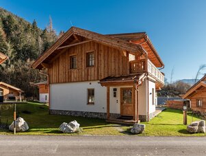 Traditionelles Holz-Chalet mit weißem Sockel in Bergdorf