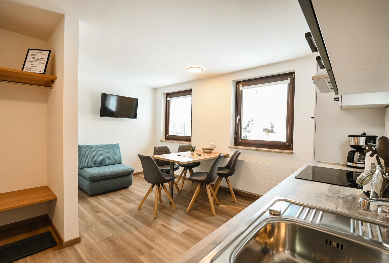 Offener Wohnbereich mit Sofa, Esstisch und Küche