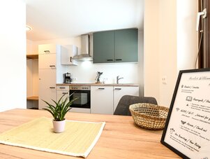 Helle moderne Küchenzeile mit grauen Oberschränken und Esstisch