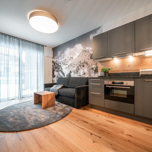 Moderner offener Wohnbereich mit Küche und grauer Couch