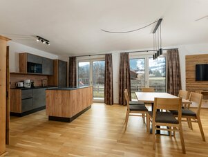 Offene Küche und Essbereich mit Holzmöbeln.