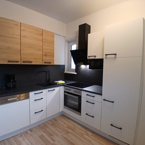 Moderne Küche mit weißen Schränken und schwarzen Arbeitsplatten