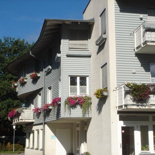 Mehrstöckiges Wohngebäude mit Balkonen und Blumen