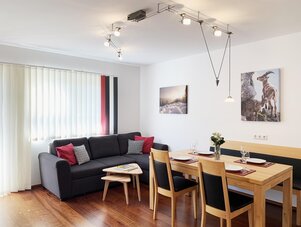 Moderner Wohn- und Essbereich mit Sofa und Esstisch.