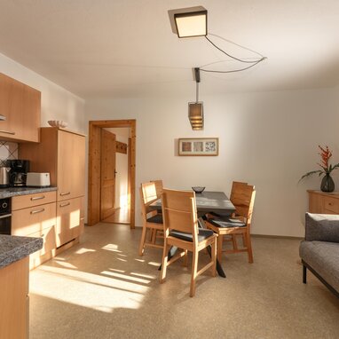 Heller Küchen- und Essbereich mit Holzmöbeln und Sofa