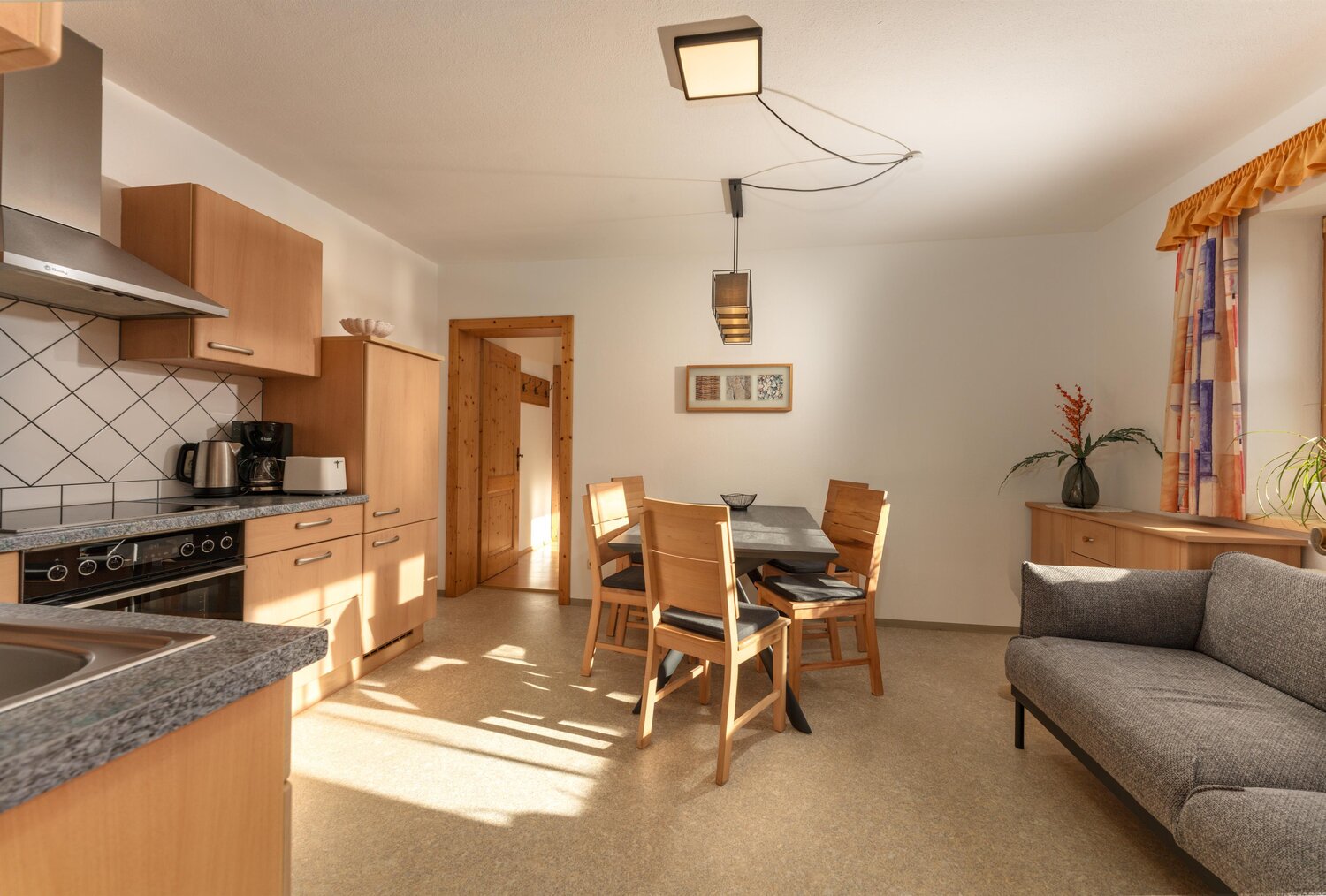 Heller Küchen- und Essbereich mit Holzmöbeln und Sofa