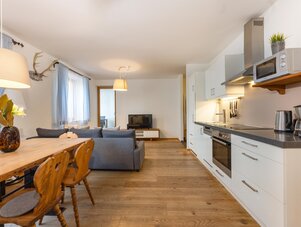 Offener Wohnbereich mit Esstisch, Sofa und Küche