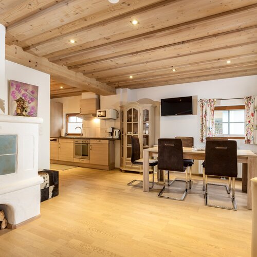 Offener Wohnbereich mit Küche, Esstisch und Kamin