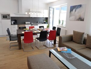 Heller offener Küchen- und Essbereich mit Sofa