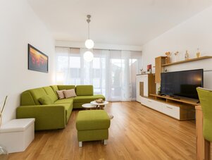 Wohnzimmer mit grüner Eckcouch und TV-Möbel