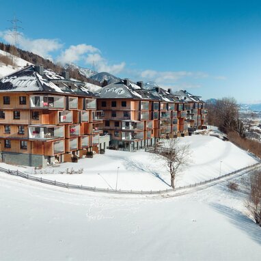 Row of wooden apartment buildings on snowy hillside