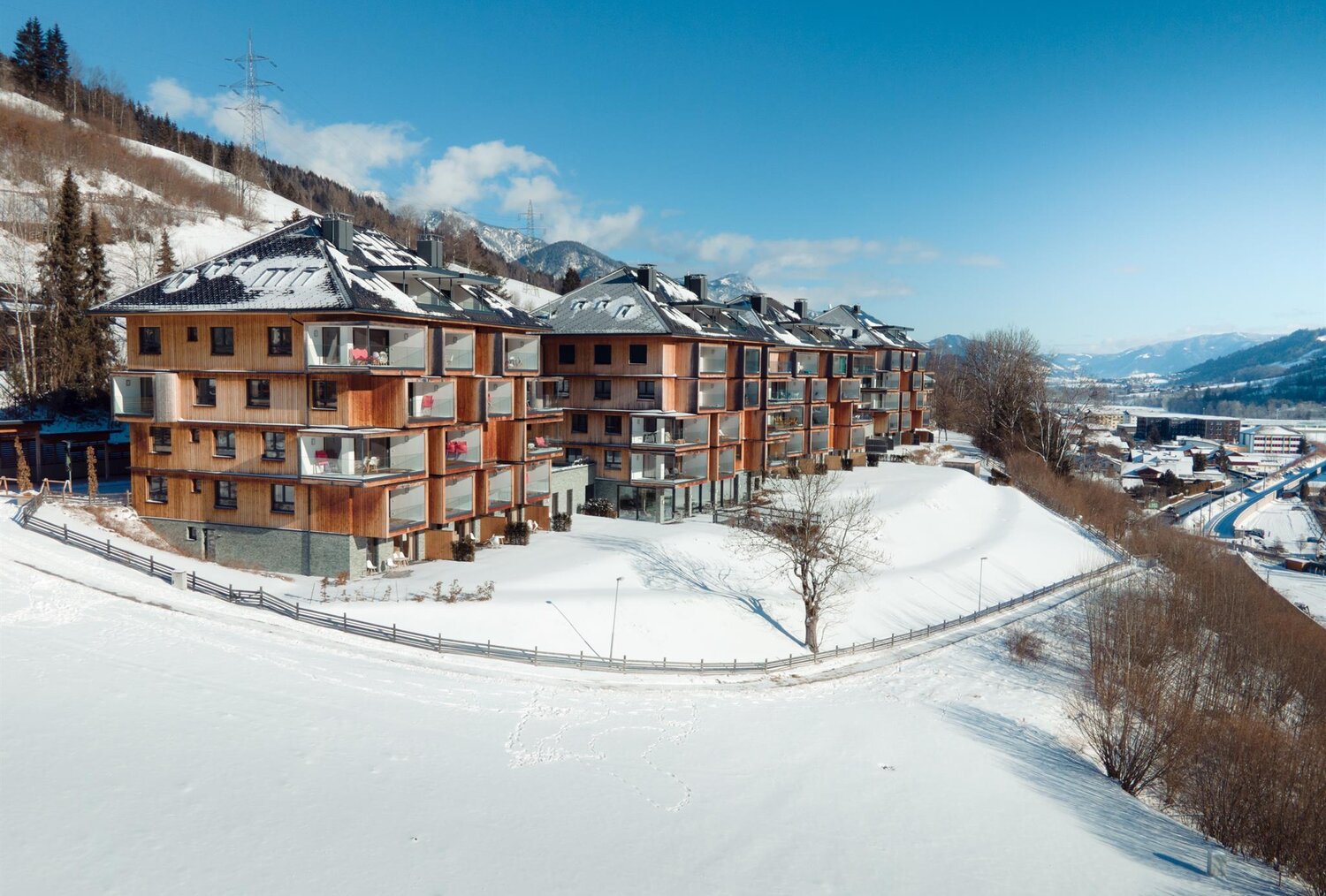Row of wooden apartment buildings on snowy hillside