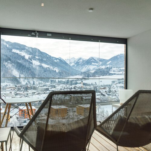 Gemütliche Balkon-Sitzgruppe mit Blick auf verschneite Berge