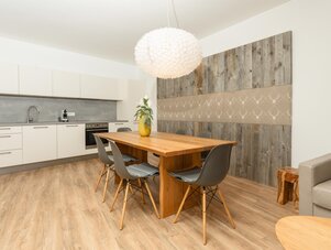 Helles Küchen- und Esszimmer mit Holztisch und Kronleuchter