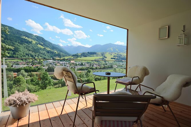 Balcony seating with fluffy chairs overlooking valley and mountains