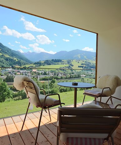 Balcony seating with fluffy chairs overlooking valley and mountains