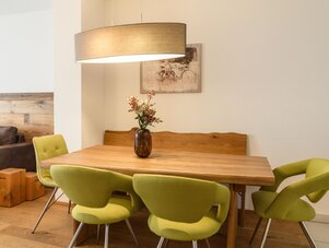 Holztisch mit limegrünen Stühlen in hellem Esszimmer