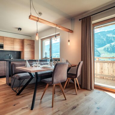 Offener Küchen- und Essbereich mit Holzmöbeln und Bergblick