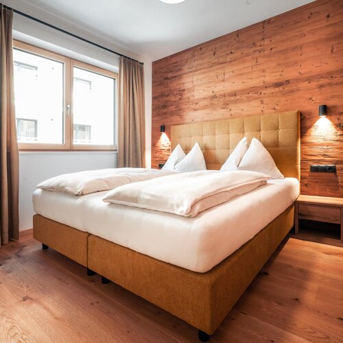 Schlafzimmer mit Holzwand-Akzent und großem Bett