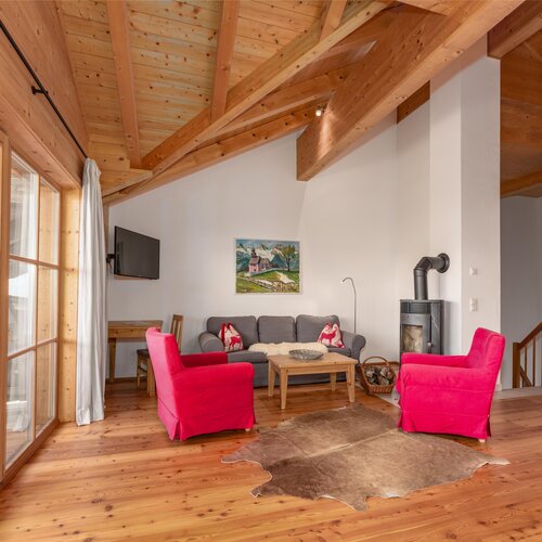 Gemütliches Holz-Wohnzimmer mit roten Sesseln und Kamin