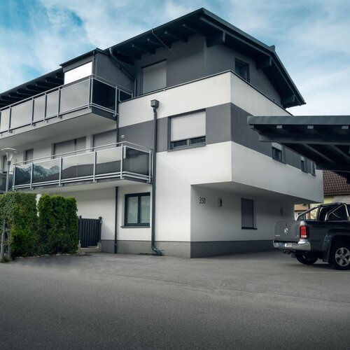 Mehrstöckiges Wohngebäude mit Balkonen und Carport