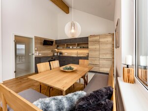 Offene Küche mit Holzschränken und Esstisch