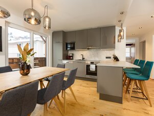 Offene Küche und Essbereich mit grauen Schränken und Insel