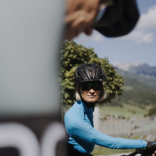 Frau Radfahrerin mit Helm und Sonnenbrille fährt draußen