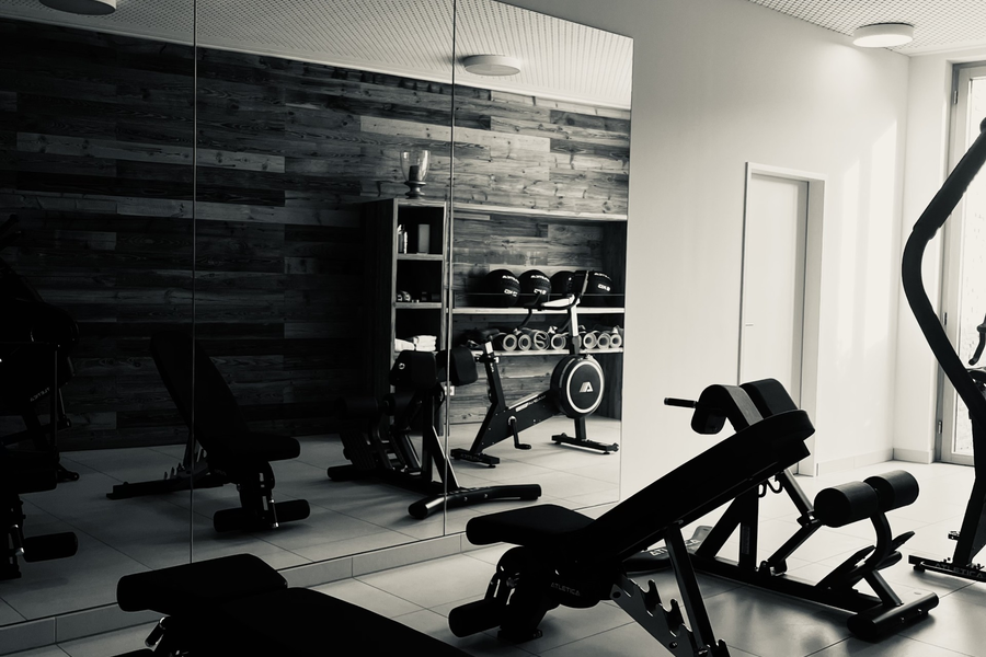 Modern gym interior with benches and weight machines.