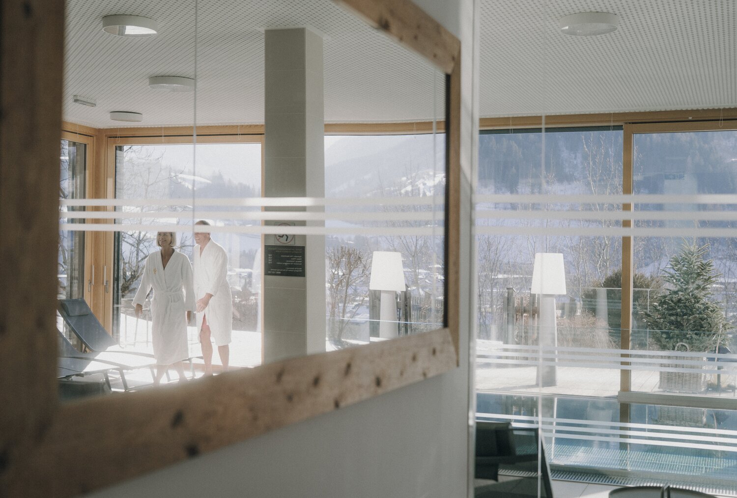 Two robe-clad guests by glass spa lobby